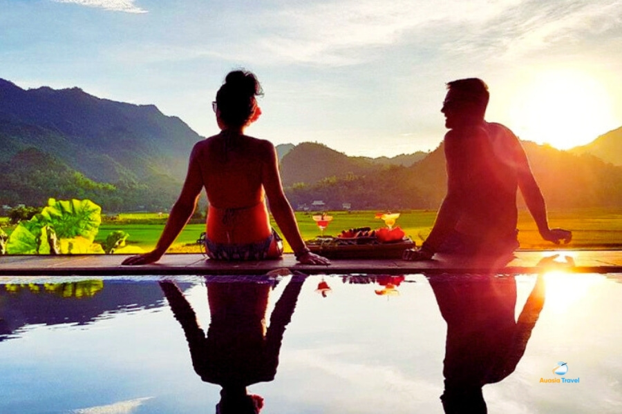 Couple relaxing by infinity pool at sunset Mai Chau Vietnam – Auasia Travel